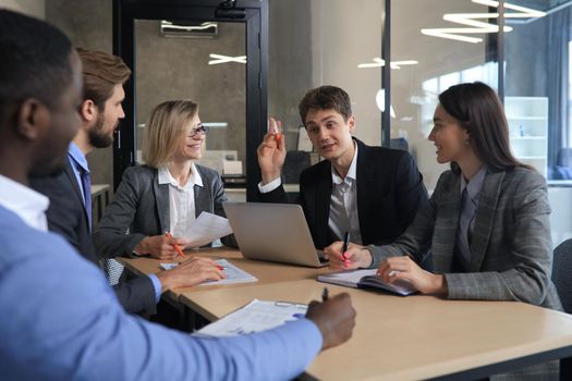 Group of happy young business people in a meeting at office