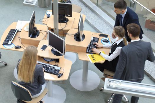 Top view of buiness team brainstorming while sitting at the office table together