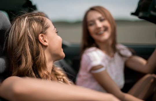 close up.attractive girlfriends traveling in a car on a summer day