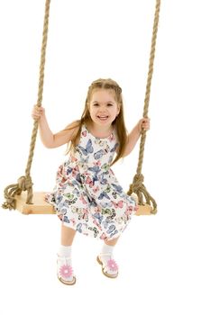 Beautiful little girl swinging on a swing. The concept of family happiness, summer holidays. Isolated on white background.