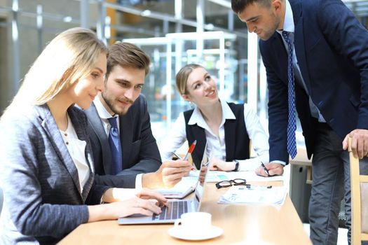 Startup business team on meeting in modern bright office interior and working on laptop