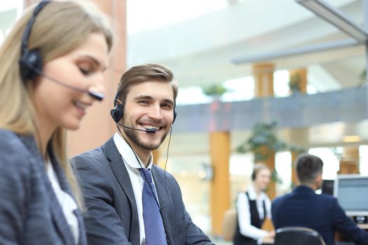 Happy young male customer support executive working in office