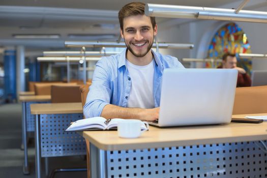 Young student working on laptop in library