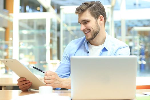 Portrait of young man sitting at his desk in the office