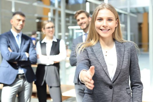 woman with an open hand ready for handshake in office