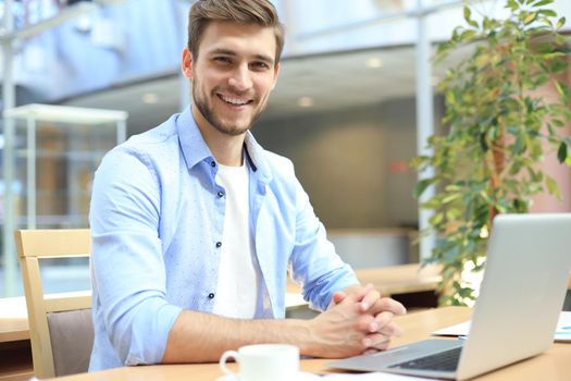 Portrait of young man sitting at his desk in the office