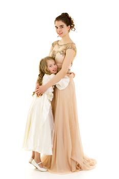 Beautiful young girl hugging her little sister. The concept of a happy childhood, family values. Isolated on white background.