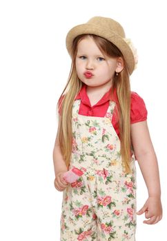 Portrait of cute little girl with long flowing blond hair to her waist. The girl pouted. In a hat and shorts , the girl is holding a Popsicle. Close-up - Isolated on white background