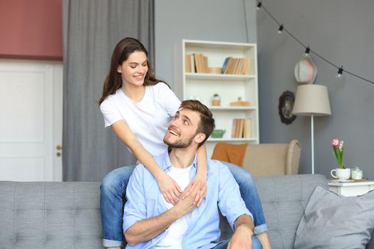 Beautiful woman with boyfriend spending quality time together on sofa at home in the living room