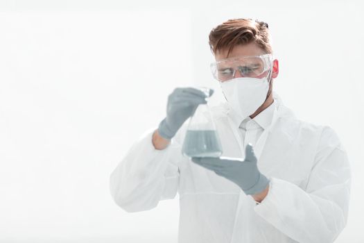 background image.scientist examining the liquid in the flask.photo with copy space