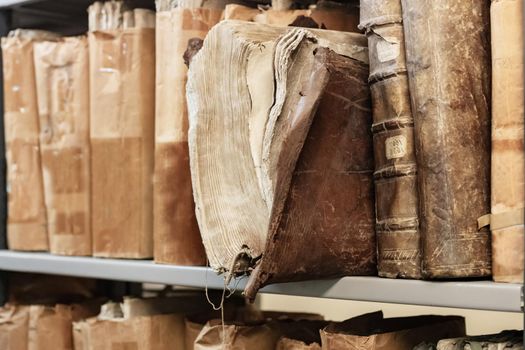 Old worn 17th century books on a shelf in the library's archives