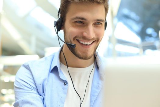 Happy young male customer support executive working in office