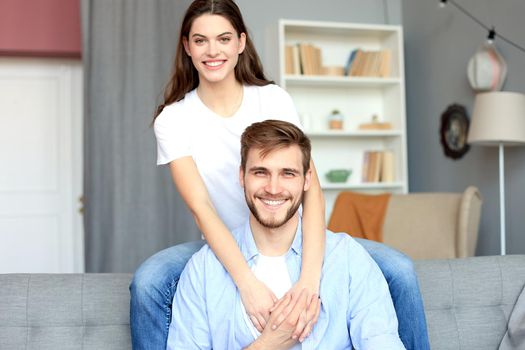 Beautiful woman with boyfriend spending quality time together on sofa at home in the living room