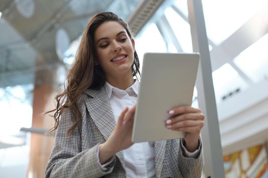 Young smiling businesswoman in office working on digital tablet