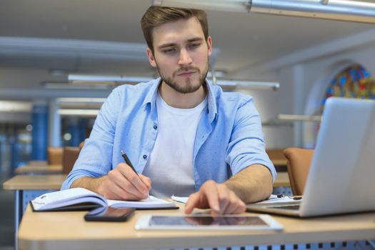 Portrait of young man sitting at his desk in the office