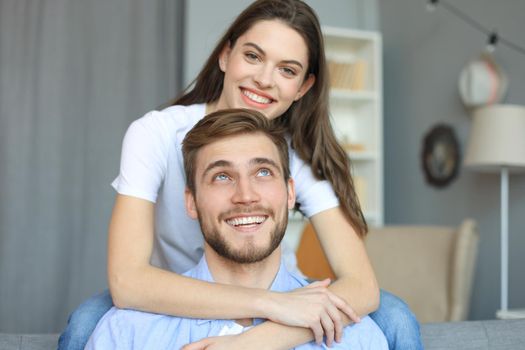 Beautiful woman with boyfriend spending quality time together on sofa at home in the living room