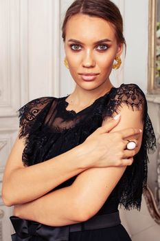 young pretty lady in black lace fashion style dress posing in rich interior of royal hotel room, luxury lifestyle people concept close up