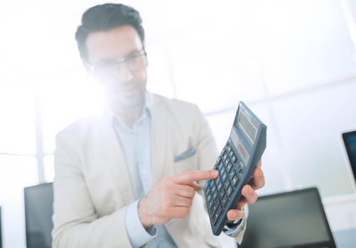 confident businessman pointing to calculator.photo with copy space