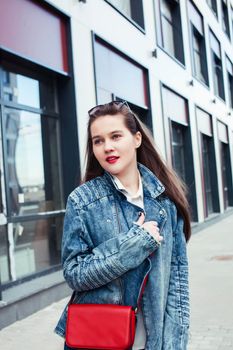 young pretty brunette business woman posing against modern building in glasses holding coffee, lifestyle people concept close up