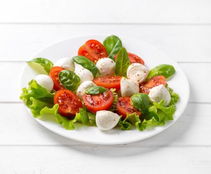 Big plate full of greek salad with feta and seasoned tomatoes, greenies, spinach
