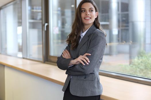 Attractive businesswoman standing near desk in the office