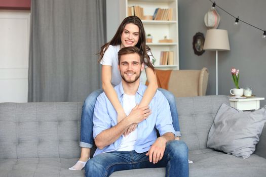 Beautiful woman with boyfriend spending quality time together on sofa at home in the living room