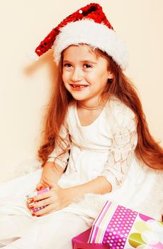 little cute girl in santas red hat waiting for Christmas gifts. holiday lifestyle people concept close up