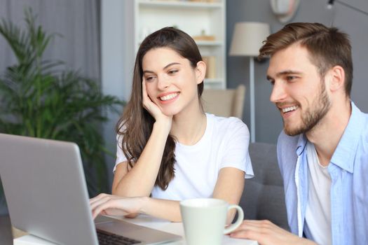 Couple pointing while working together on laptop