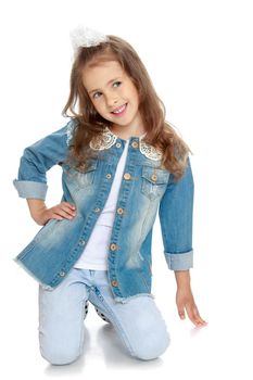 Portrait of adorable little girl in denim suit which is on the knees Studio - Isolated on white background