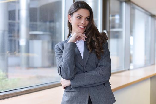 Attractive businesswoman standing near desk in the office