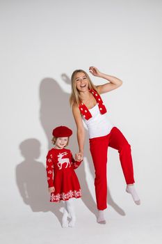 little girl in red dress and hat poses for the camera with her cheerful mother