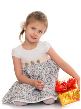Cute little girl sitting on floor with gift in hand - Isolated on white background