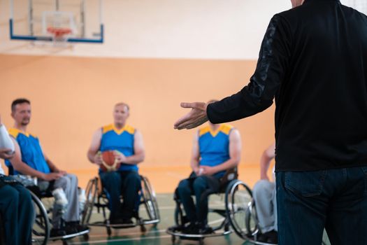 selector I explain new tactics to basketball players in wheelchairs, players sit in wheelchairs listening to the selector. Selective focus 