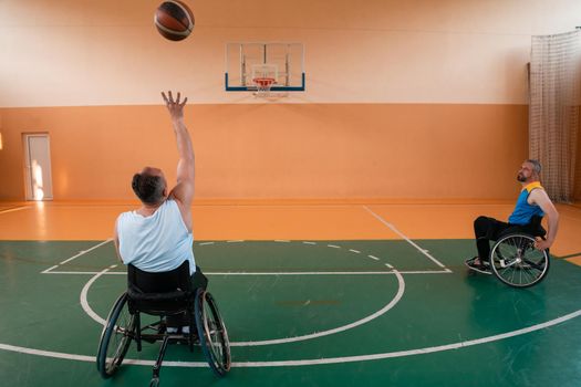 disabled war veterans in action while playing basketball on a basketball court with professional sports equipment for the disabled. High quality photo. Selective focus 