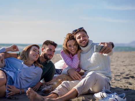 Group Of Young Friends Spending The Day On A Beach during autumn day