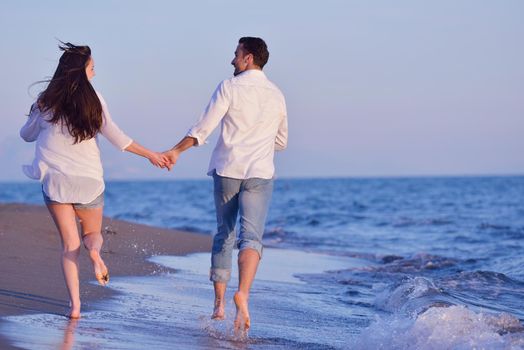 happy young romantic couple in love have fun on beautiful beach at beautiful summer day