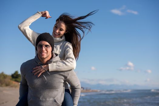 Men Giving Piggy Back Rides his girlfriend At Sunset By The Sea, autumn time