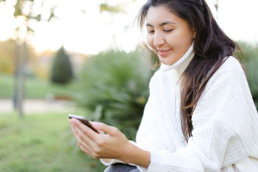 Focus on japanese woman keeping smartphone and smiling. Concept of asian modern technology.