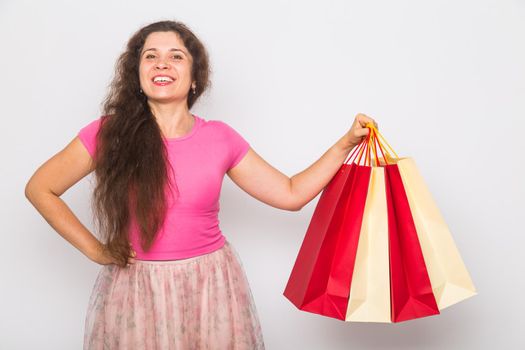 Portrait of young happy smiling woman with shopping bags, over white background. Purchase, sale and people concept.