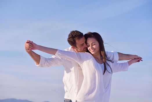 happy young romantic couple in love have fun on beautiful beach at beautiful summer day