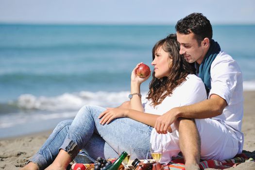 happy young couple enjoying  picnic on the beach and have good time on summer vacations