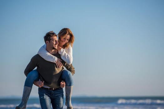 Men Giving Piggy Back Rides to his girlfriend At Sunset By The Sea, autumn time