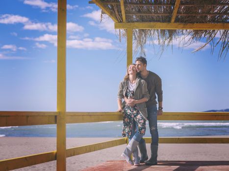 Happy couple enyojing time together on beach during autumn day colored filter