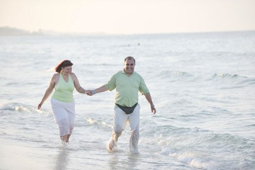 happy senior mature elderly people couple have romantic time on beach at sunset 