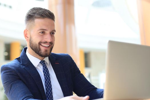 Portrait of young man sitting at his desk in the office