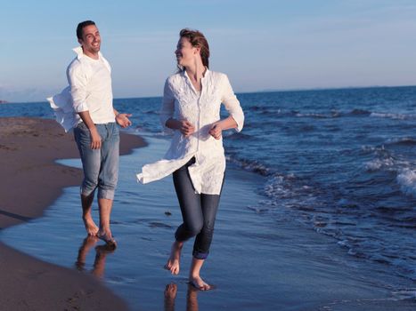 happy young romantic couple in love have fun on beautiful beach at beautiful summer day