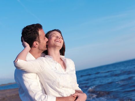 happy young romantic couple in love have fun on beautiful beach at beautiful summer day