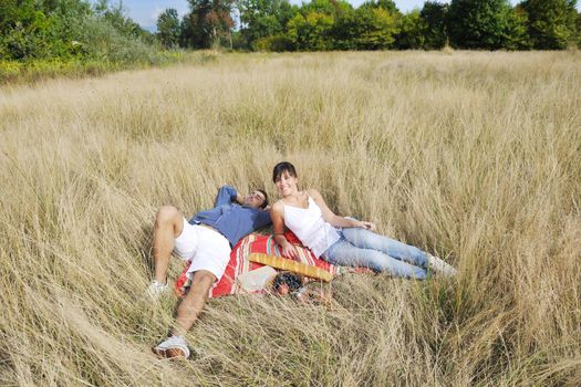 happy young couple enjoying  picnic on the countryside in the field  and have good time