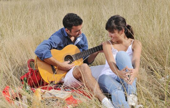 happy young couple enjoying  picnic on the countryside in the field  and have good time