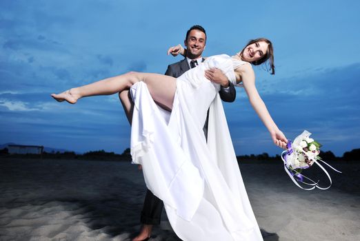 happy just married young couple celebrating and have fun at beautiful beach sunset